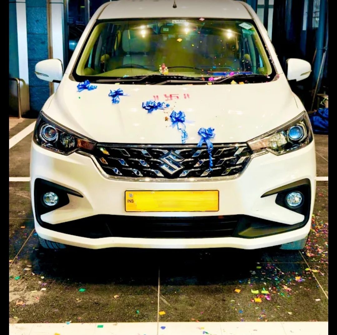 White Maruti Suzuki Ertiga taxi with roof carrier